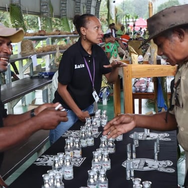 A Milne Bay Organics team member talking with visitors beside a product display