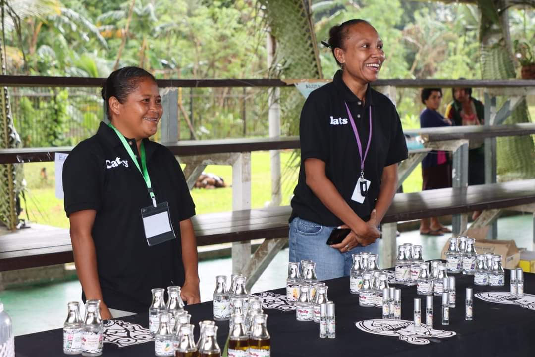 Milne Bay Organics team members presenting products at a covered display