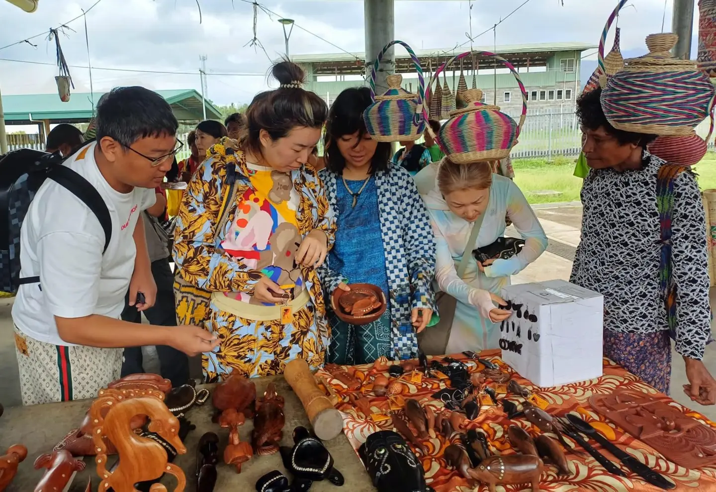 Visitors browsing local crafts in VilLink’s Discover PNG photo gallery.