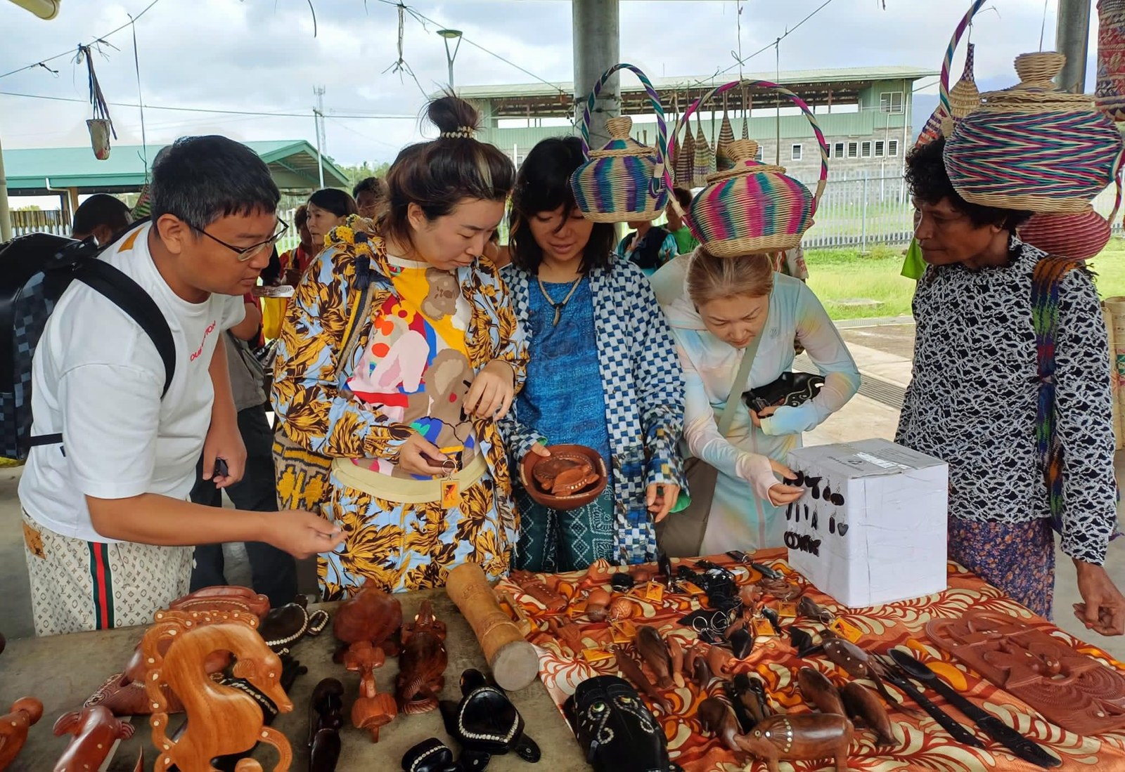 Visitors browsing local crafts in VilLink’s Discover PNG photo gallery.
