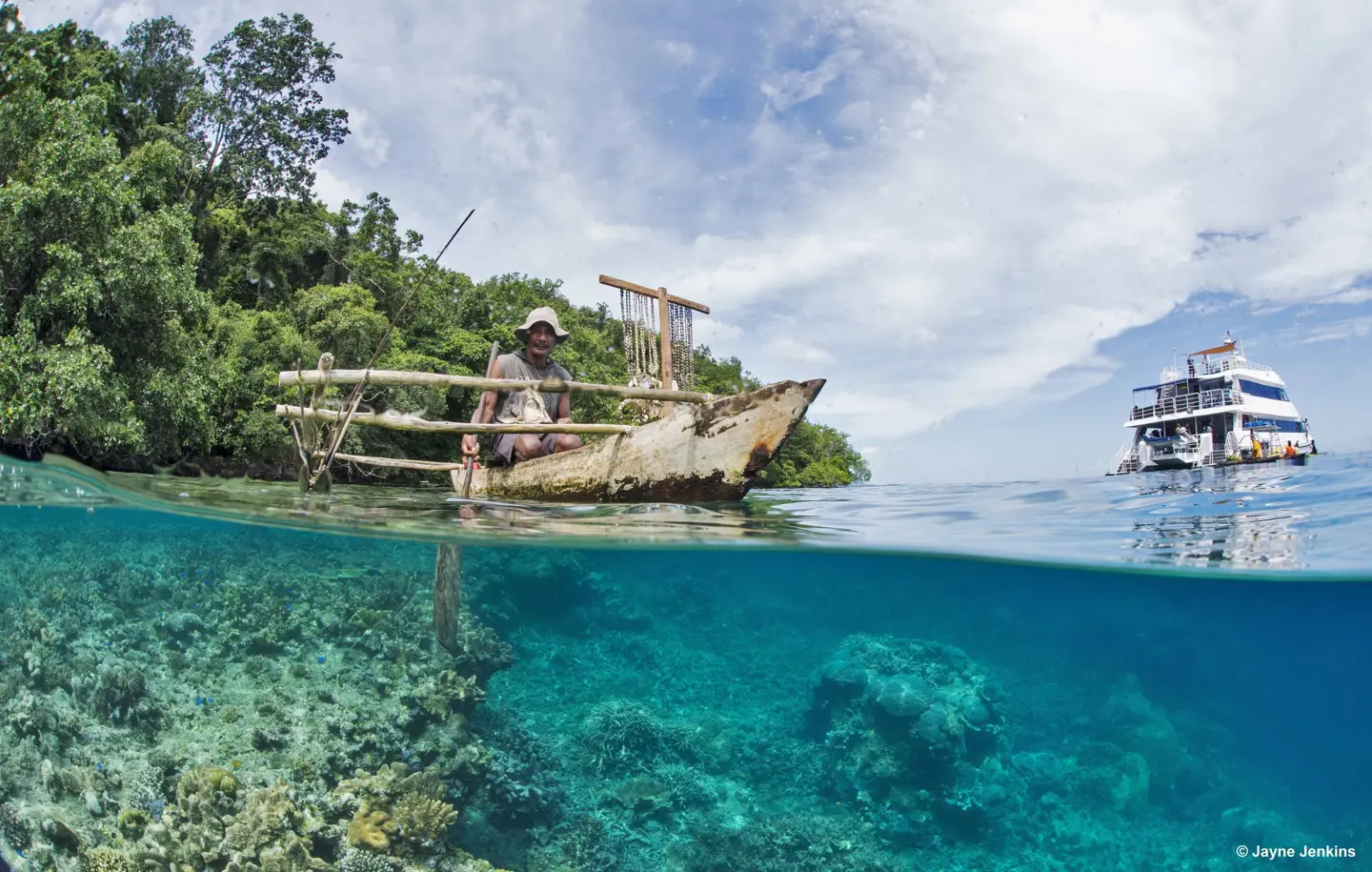 An outrigger canoe above a Milne Bay reef, photographed by Jayne Jenkins