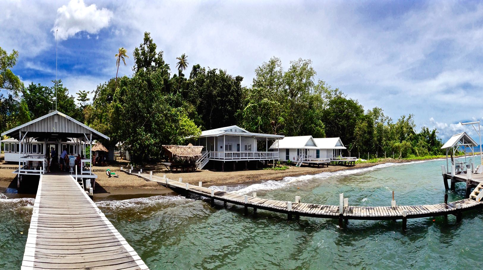 Waterfront walkway and bungalows at Driftwood Resort Alotau
