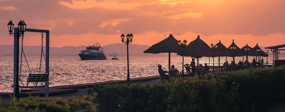 Sunset waterfront view from the Alotau International Hotel listing.