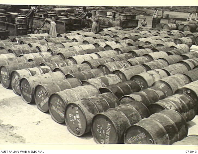 Papuan workers among rows of fuel drums at Milne Bay on 4 April 1944.